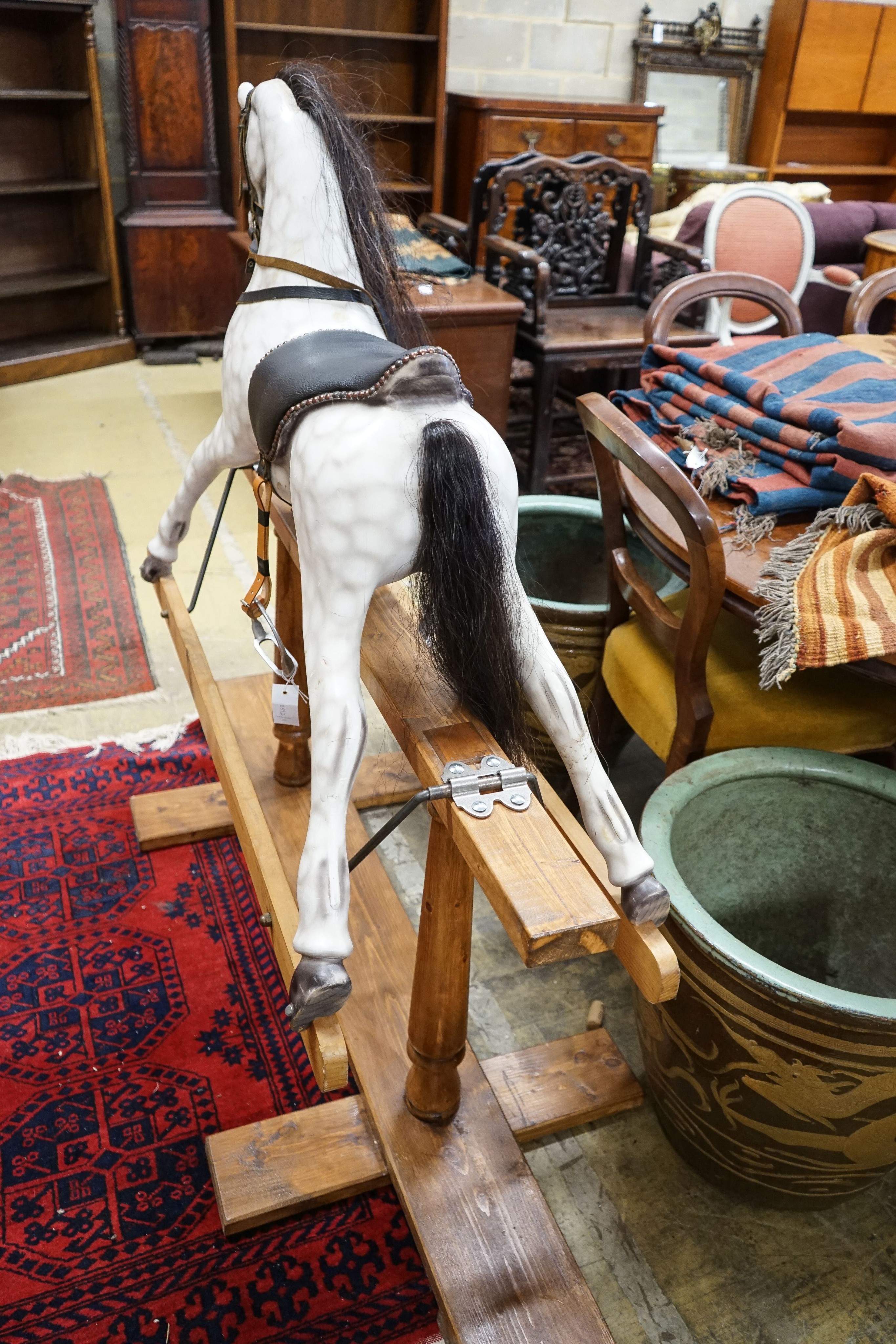 A Victorian style dapple grey rocking horse on pine stand, length 152cm, height 126cm